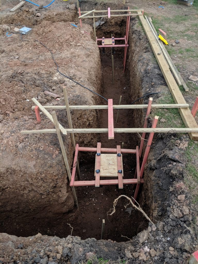A hole in the ground with wooden beams.